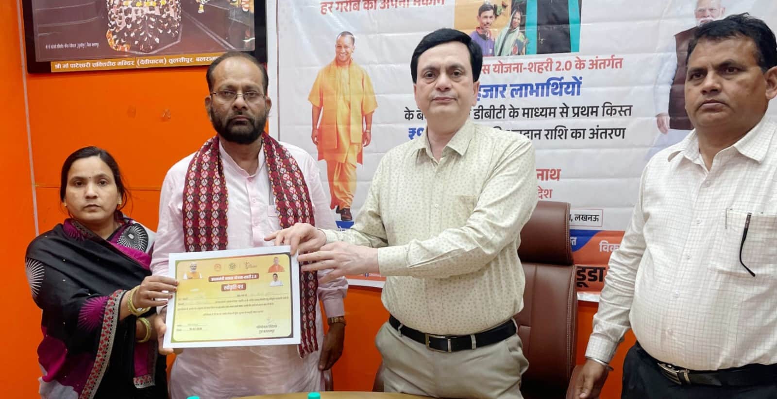 बलरामपुर के नगर पालिका सभागार में लाभार्थी को प्रमाण पत्र देते एडीएम व अन्य ।-स्रोत : विभाग