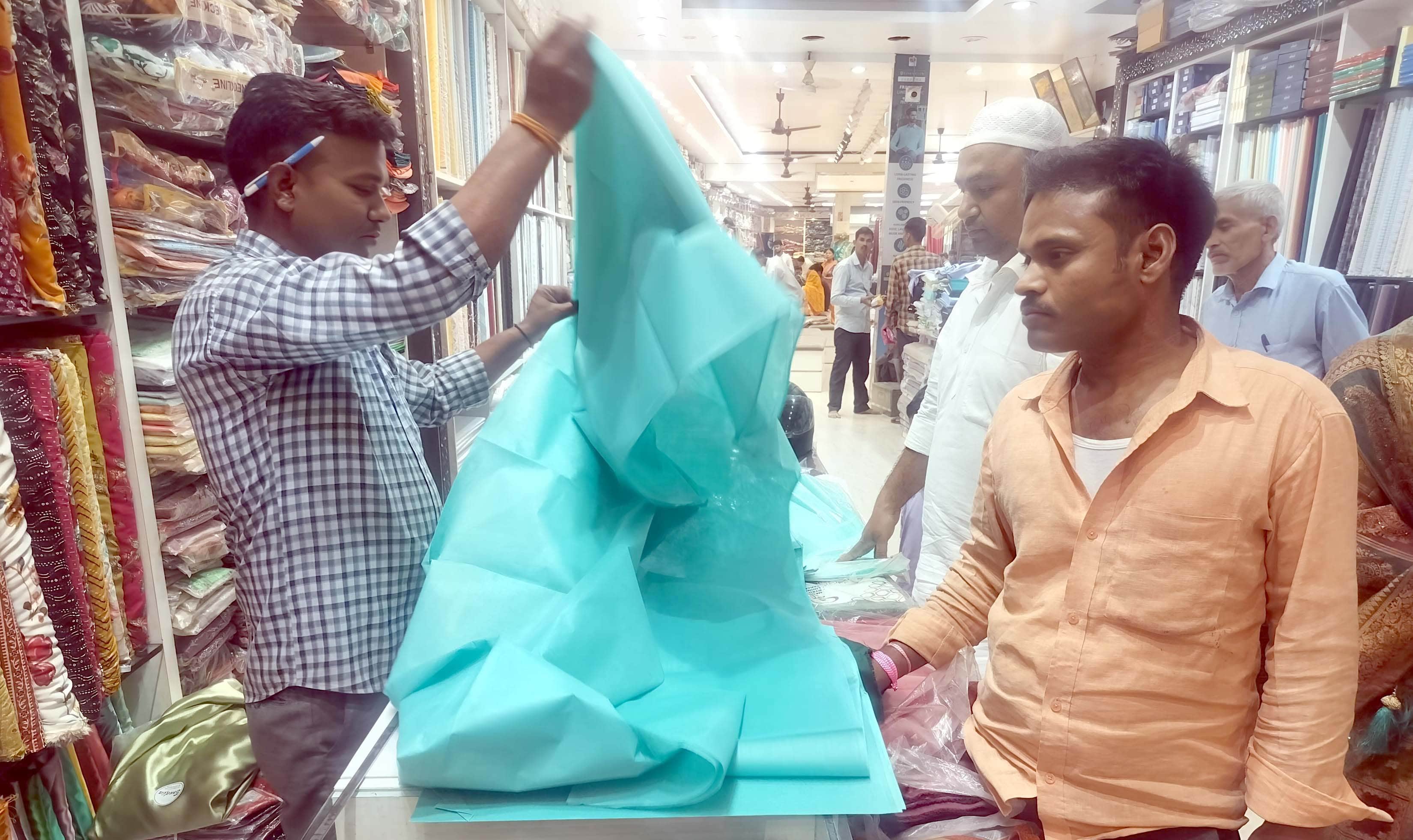 गजिया स्थित कपड़े की दुकान में खरीदारी करते लोग। स्रोत-संवाद