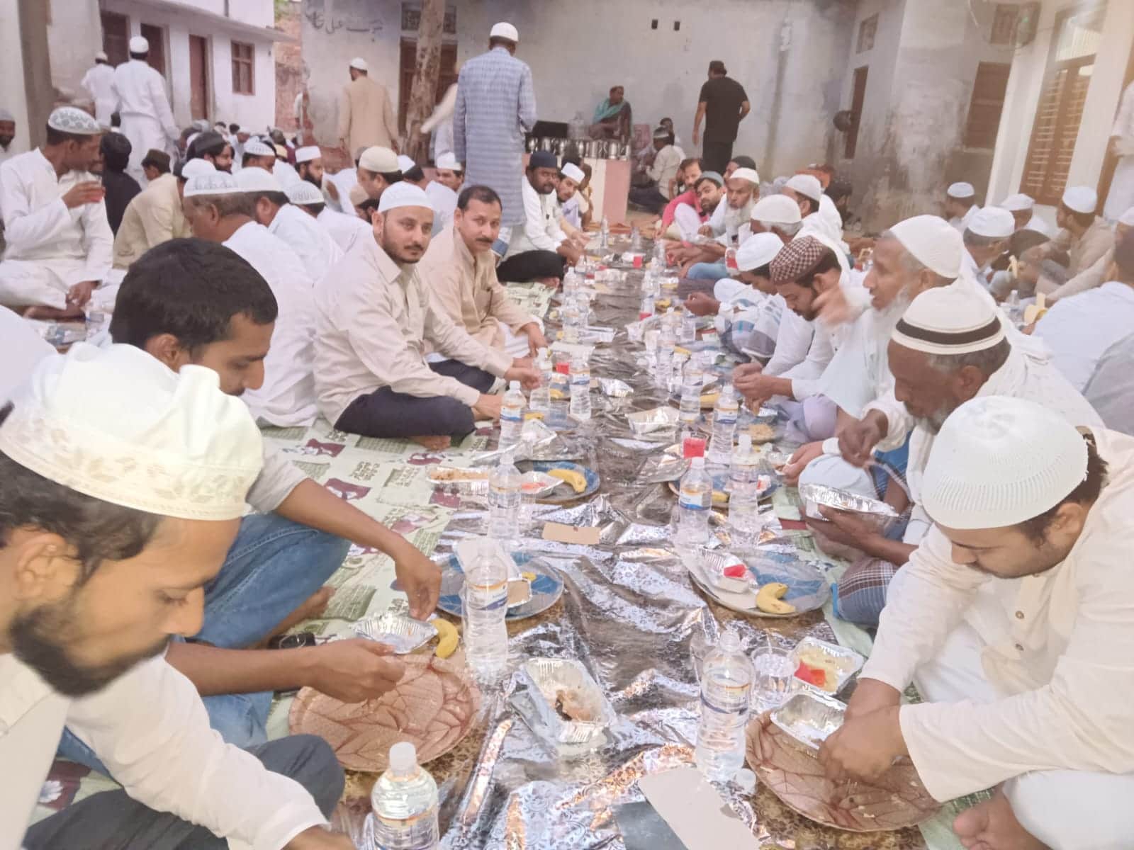 मुहम्मदाबाद गोहना के वलीदपुर के काजी टोला मुहल्ले में आयोजित इफ्तार पार्टी में इफ्तार करते रोजे