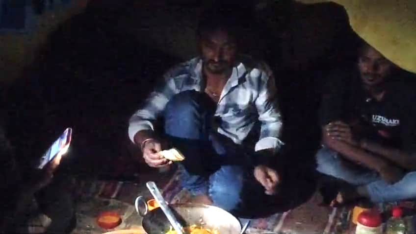 सुजानपुर मेले में मोबाइल की रोशनी से खाना बनाते हुए दुकानदार। वीडियो ग्रैव