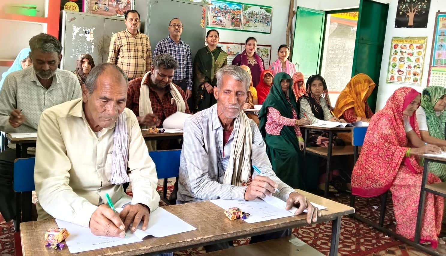 सादाबाद में परीक्षा देतीं महिलाएं व बुजुर्ग।  संवाद