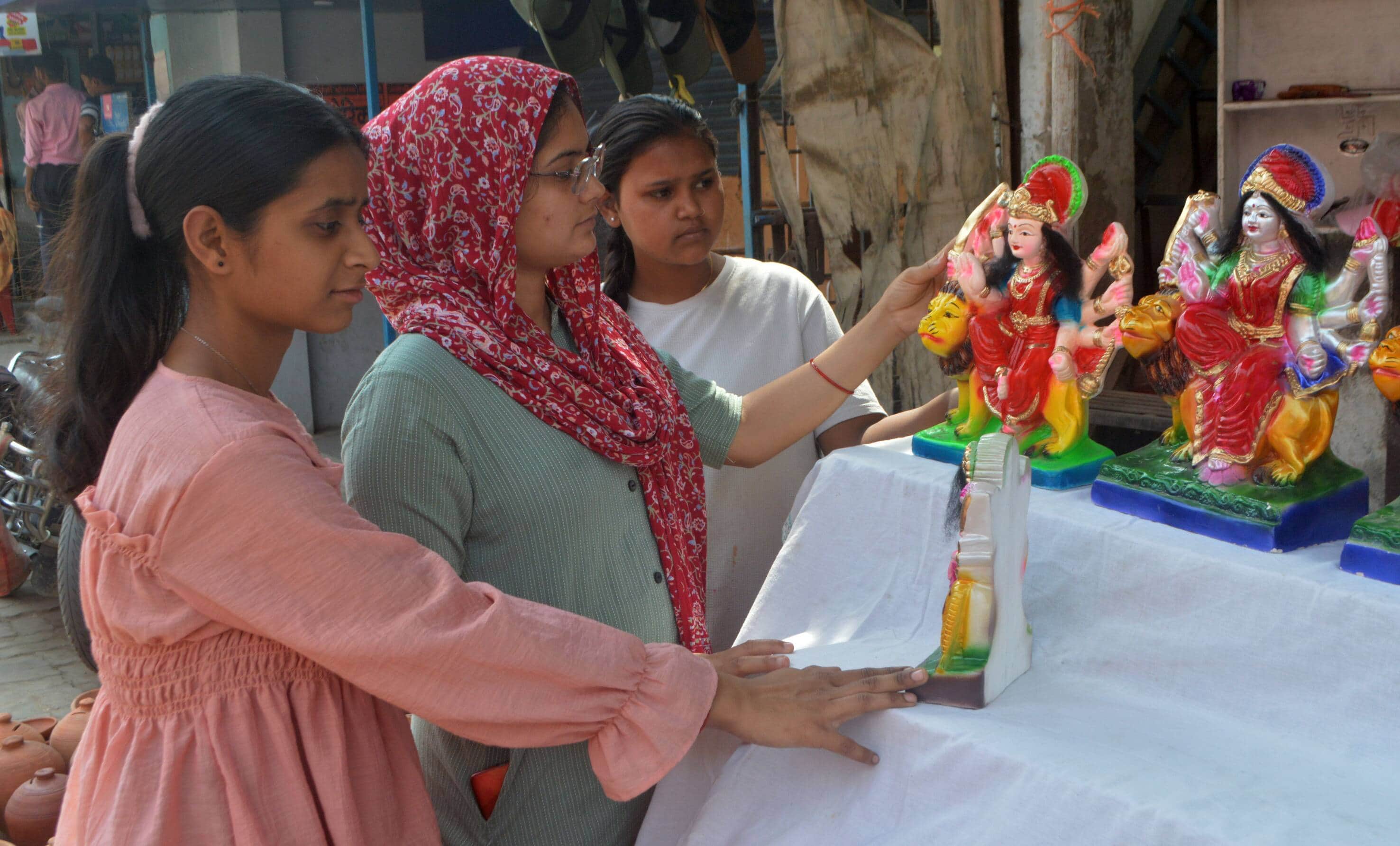 फोटो-05- नवरात्रि की तैयारियों को लेकर मूर्तियां खरीदतीं महिलाएं। संवाद