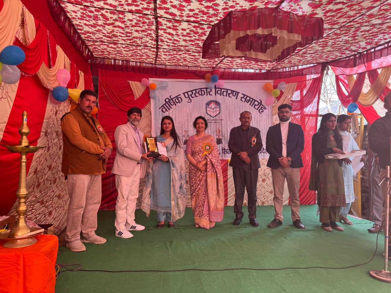 पझौता कॉलेज में मेधावी छात्रा को पुरस्कृत करते मुख्यातिथि। स्रोत: कॉलेज