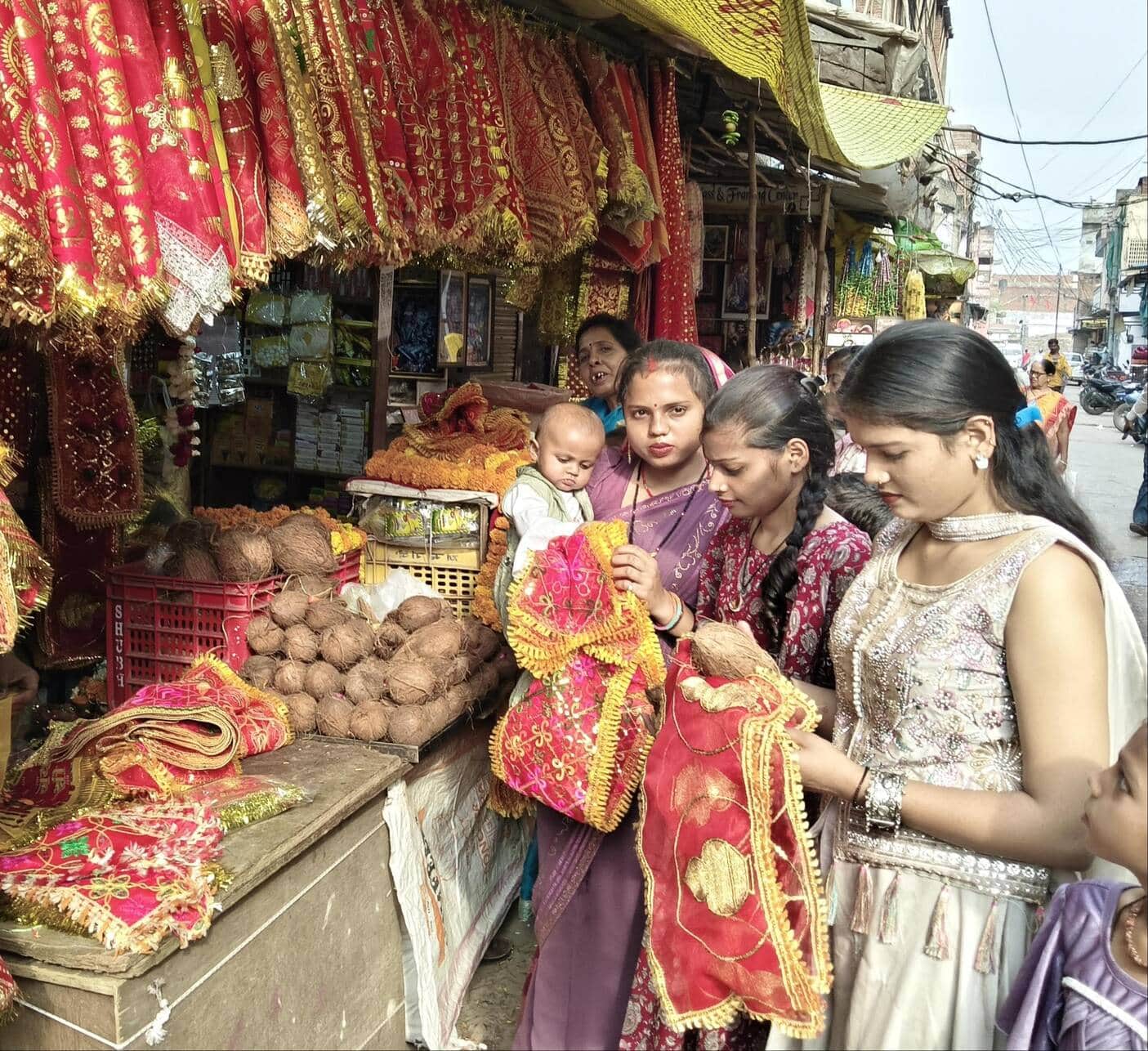 रॉबर्ट्सगंज शीतला माता मंदिर के समीप नवरात्र की तैयारी को लेकर नारियल,चुनरी की खरीदारी करती महि