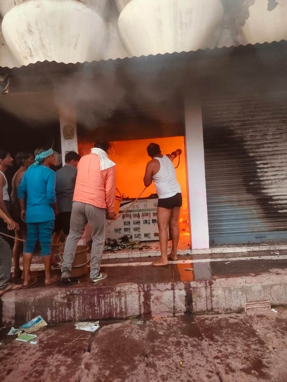 टंकी के पानी से आग बुझाने का प्रयास करते पीड़ित परिजन- संवाद