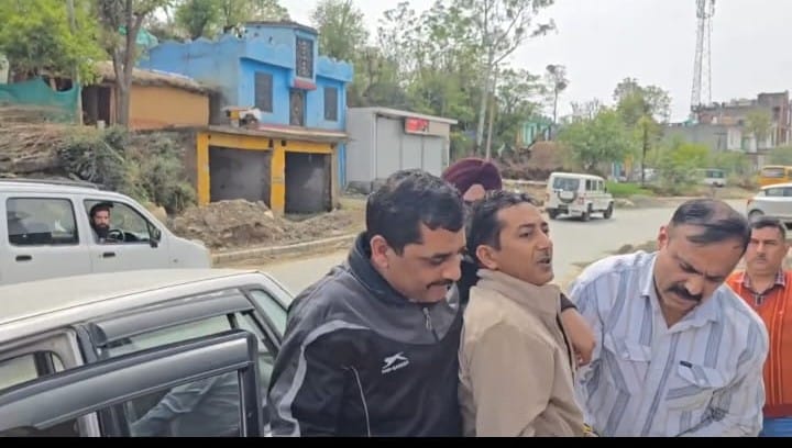 आरोपी मीटर रीडर को पकड़कर ले जाती टीम।