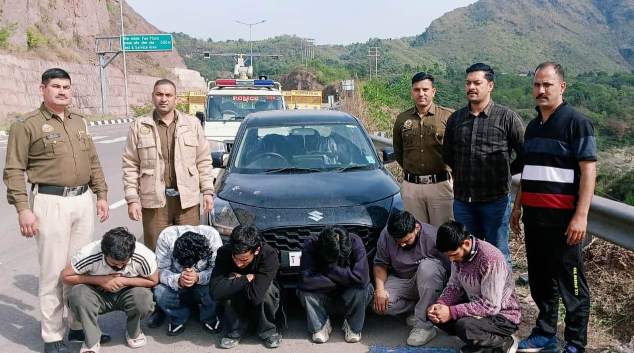 फोरलेन पर चरस के साथ पकड़े छह आरोपी नीचे बैठे हुए और मौजूद पुलिस जवान। स्रोत: जागरूक पाठक