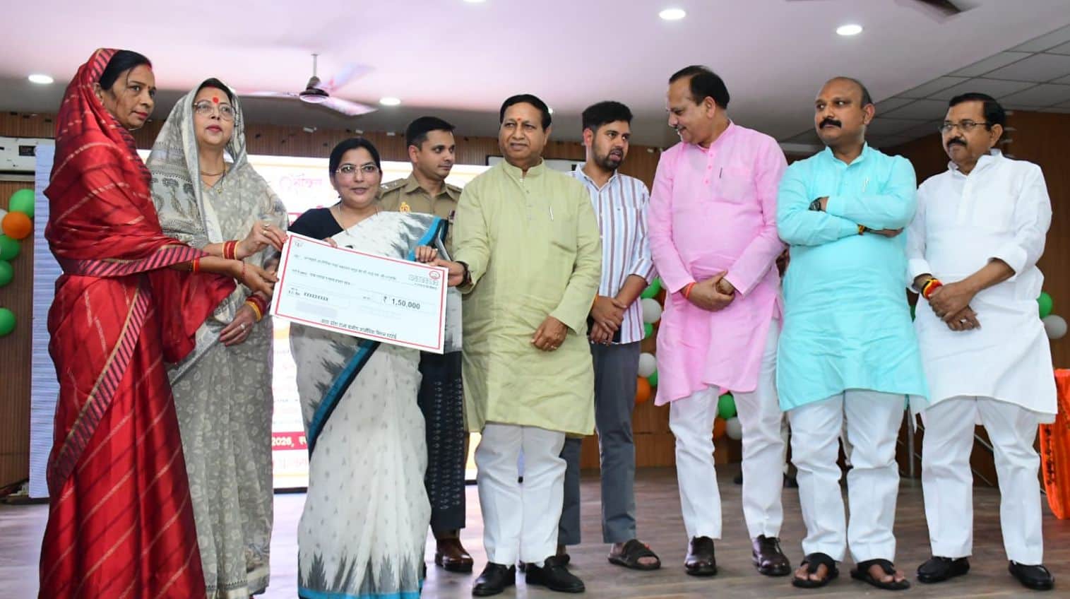 फोटो-09- गांधी भवन में लाभार्थी महिला को चक देतीं उच्च शिक्षा राज्यमंत्री रजनी तिवारी साथ में ज