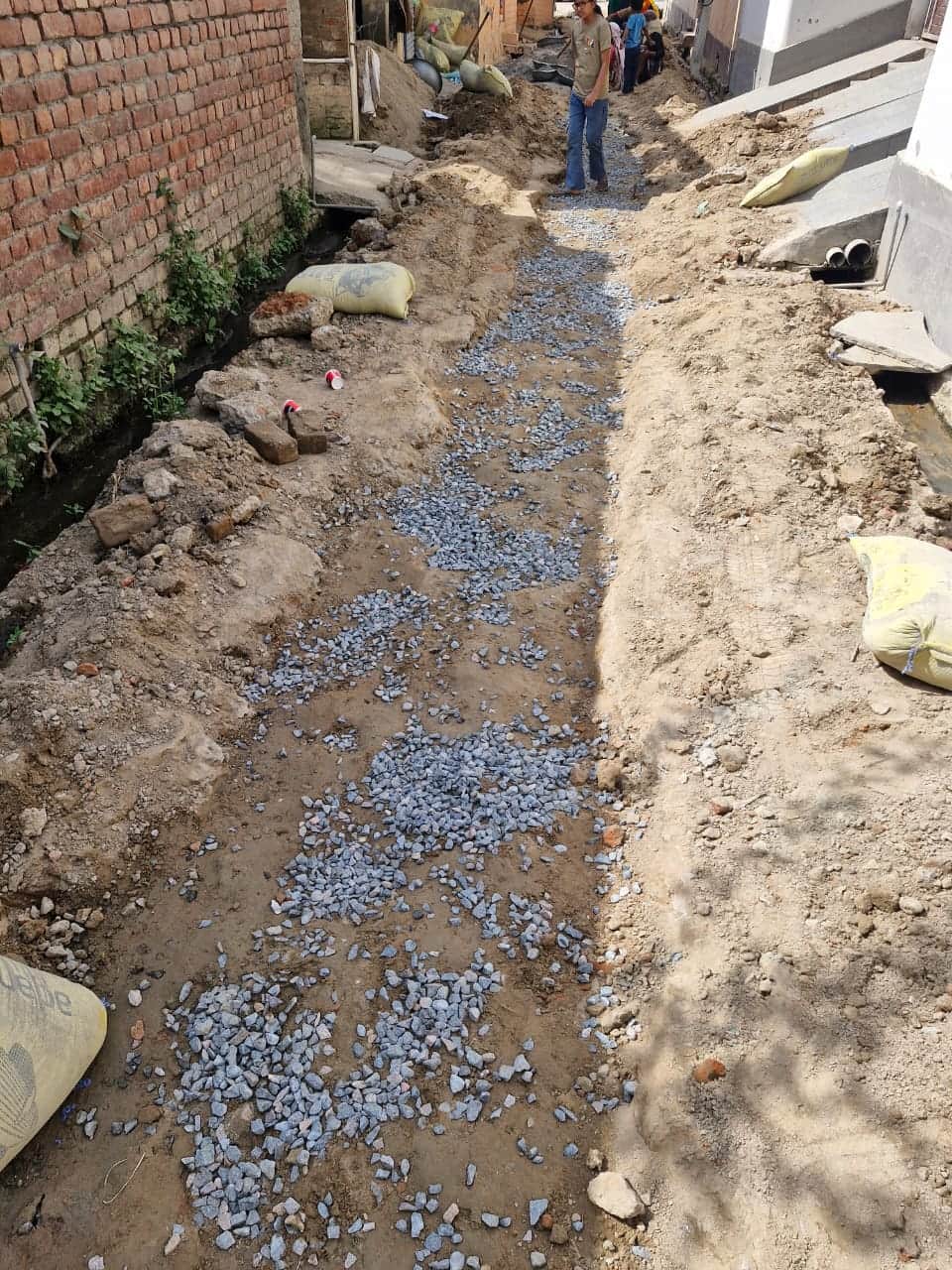 गली निर्माण से पहले रोडी डलवाने में की जा रही खानापूर्ती।  संवाद
