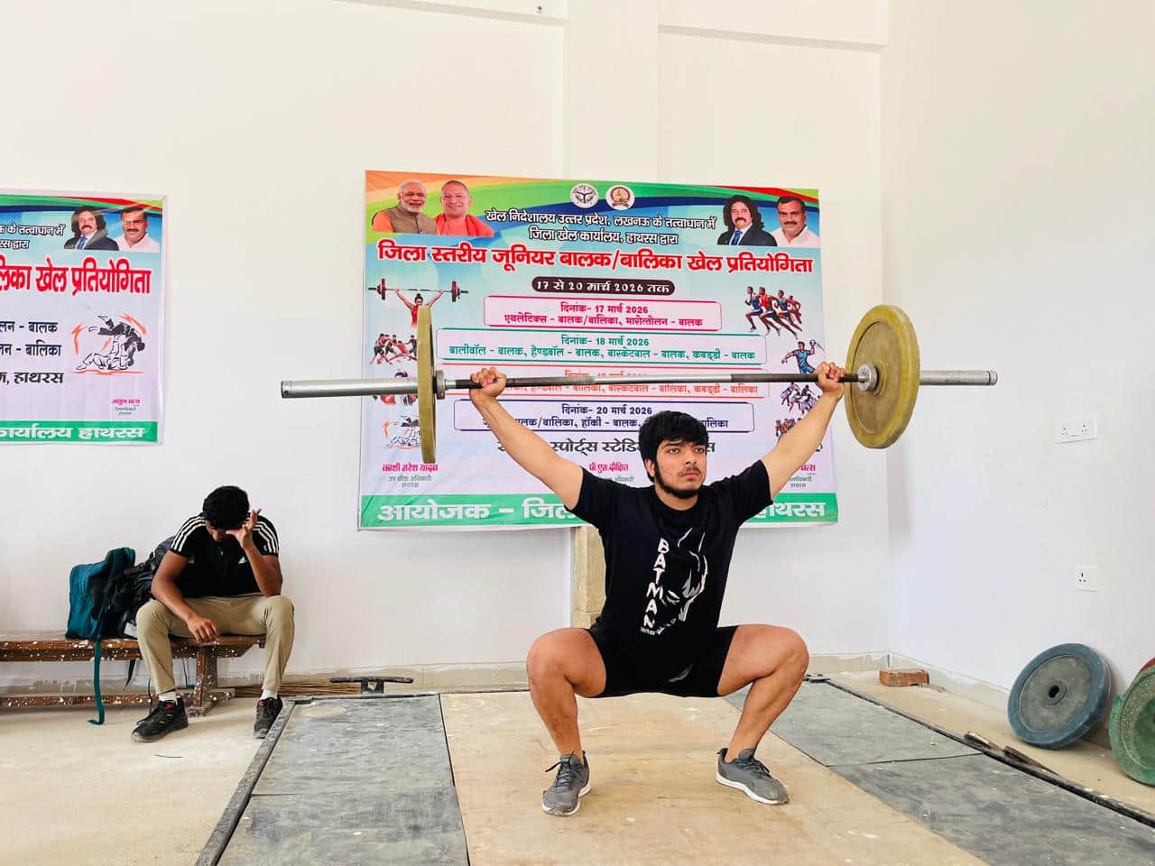 खेल स्टेडियम में भारोत्तलन प्रतियोगिता में वजन उठाता खिलाड़ी। संवाद