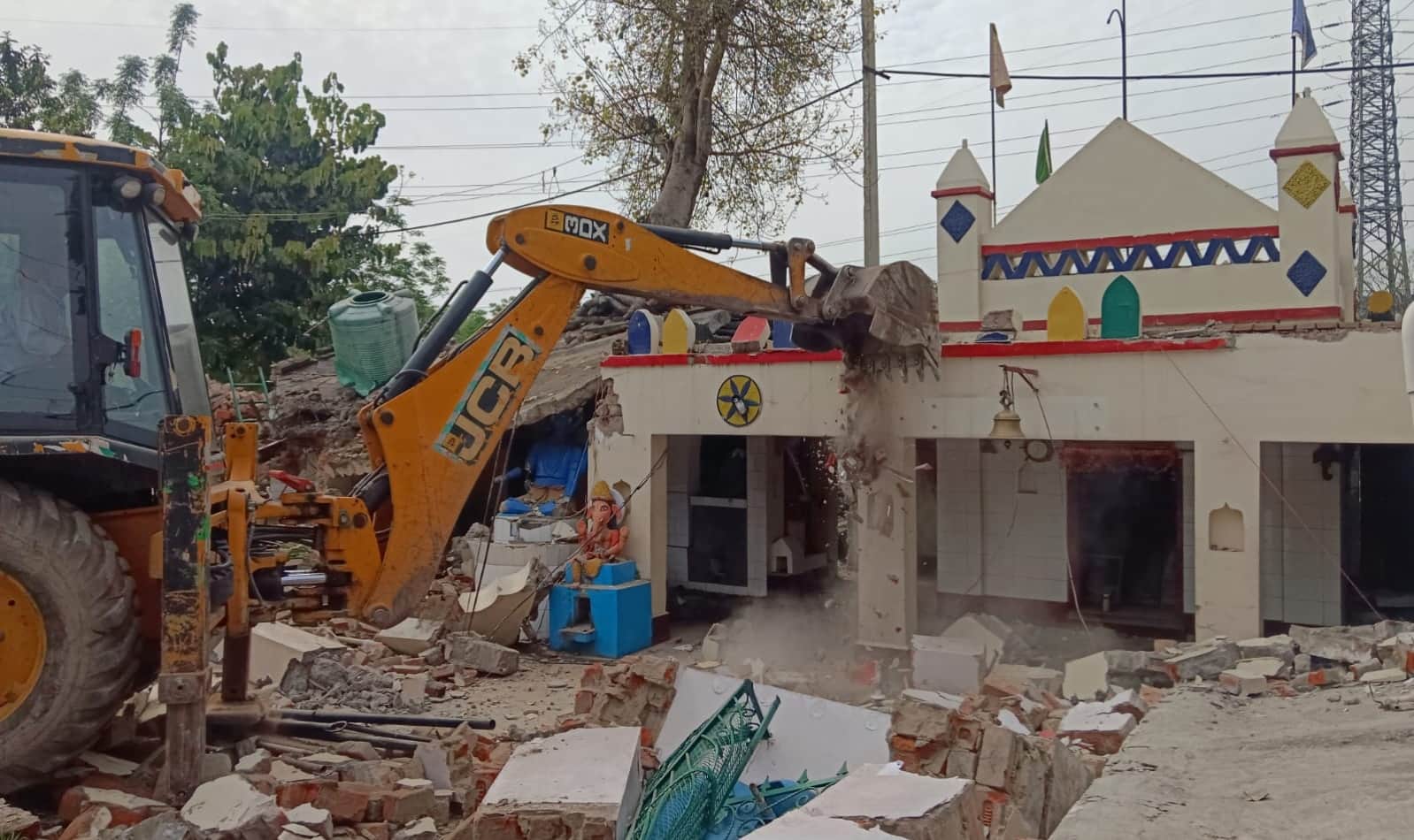 निर्माण को तोड़ती जेसीबी।