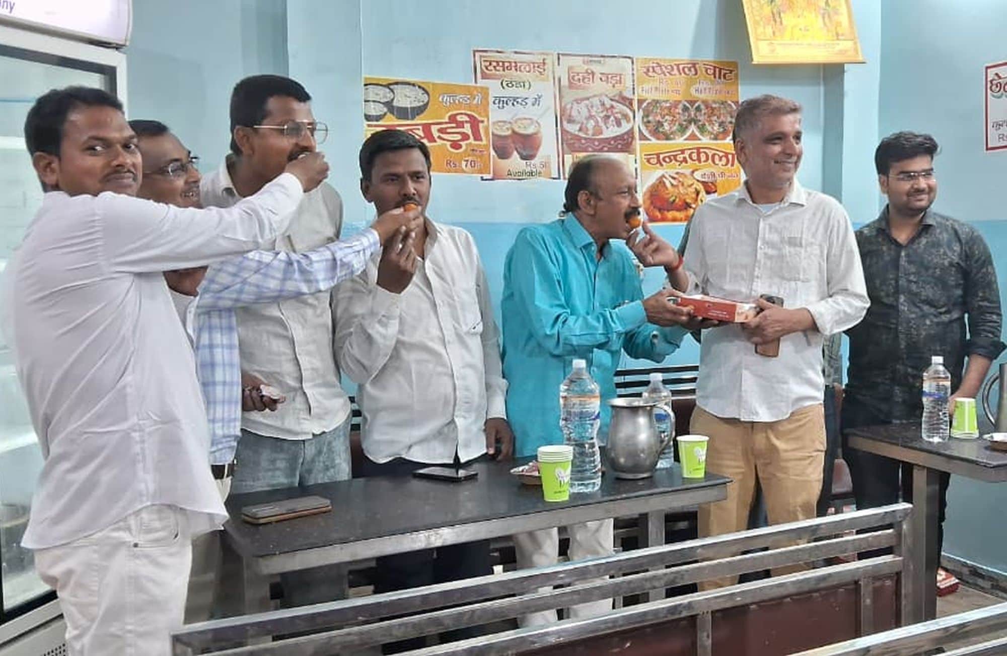  रोडवेज के निकट एक दूसरे को मिठाई खिलाकर खुशी जताते व्यापारी।