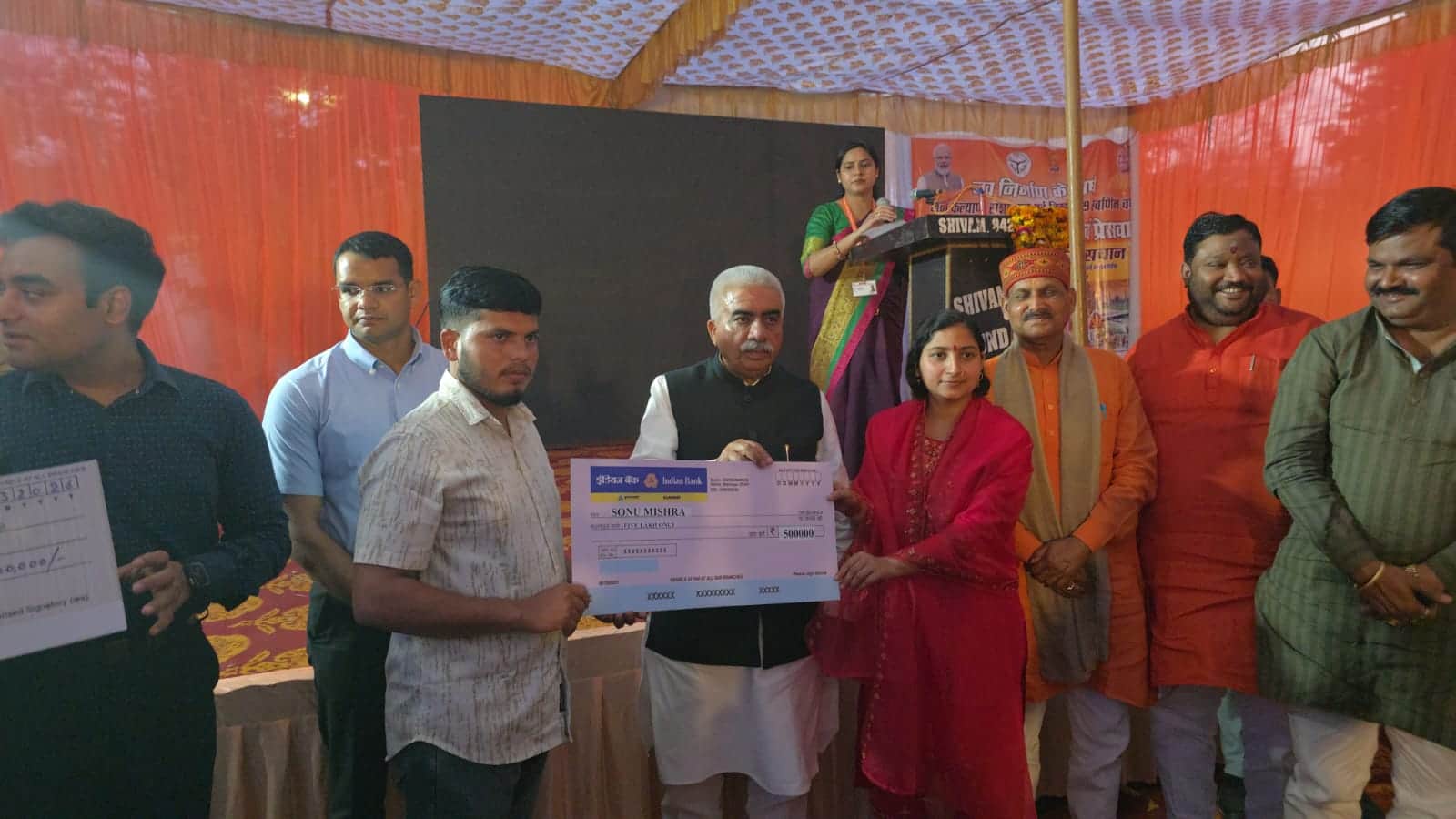 बलरामपुर में लाभार्थी को चेक प्रदान करते प्रभारी मंत्री। स्रोत विभाग