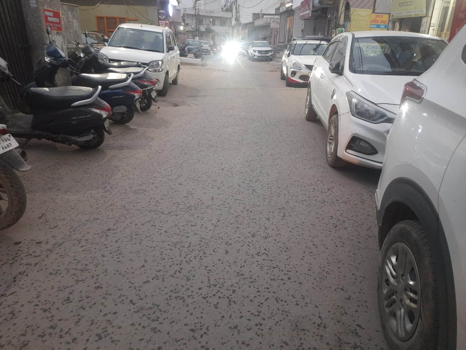 बूंदाबांदी के बीच कच्चे क्वार्टर के पास से गुजरते वाहन। संवाद