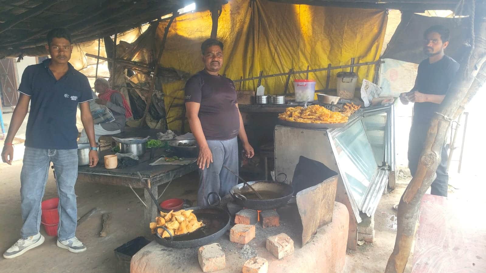 फोटो 23 : टड़ियावां में मिट्टी की भट्ठी पर लकड़ी से समोसा व मिर्चा बनाते दुकानदार प्रमोद। संवाद