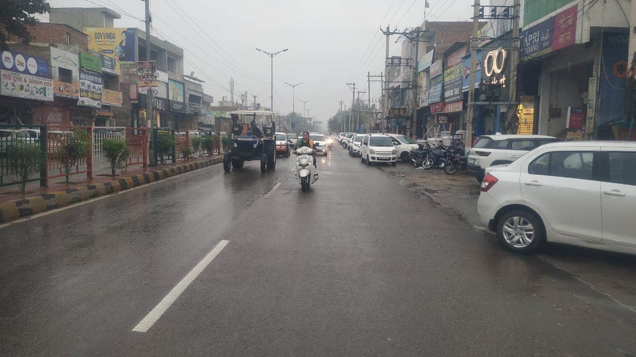 फतेहाबाद शहर में बूंदाबांदी के बीच गुजरते हुए वाहन संवाद