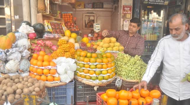 गढ़ रोड पर दुकान से फल खरीदते व्यक्ति। संवाद