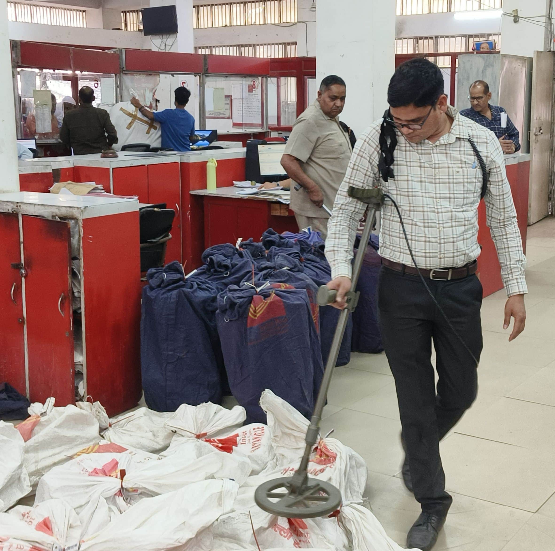 मुख्य डाकघर कार्यालय में रखे पार्सल को मशीन से चेक करते बम निरोधक दस्ता।