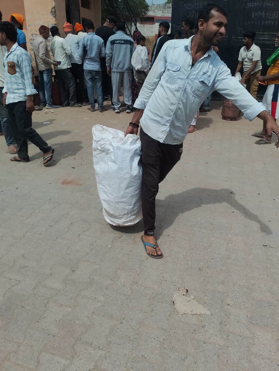 सिलिंडर लेकर जाते एक युवक।