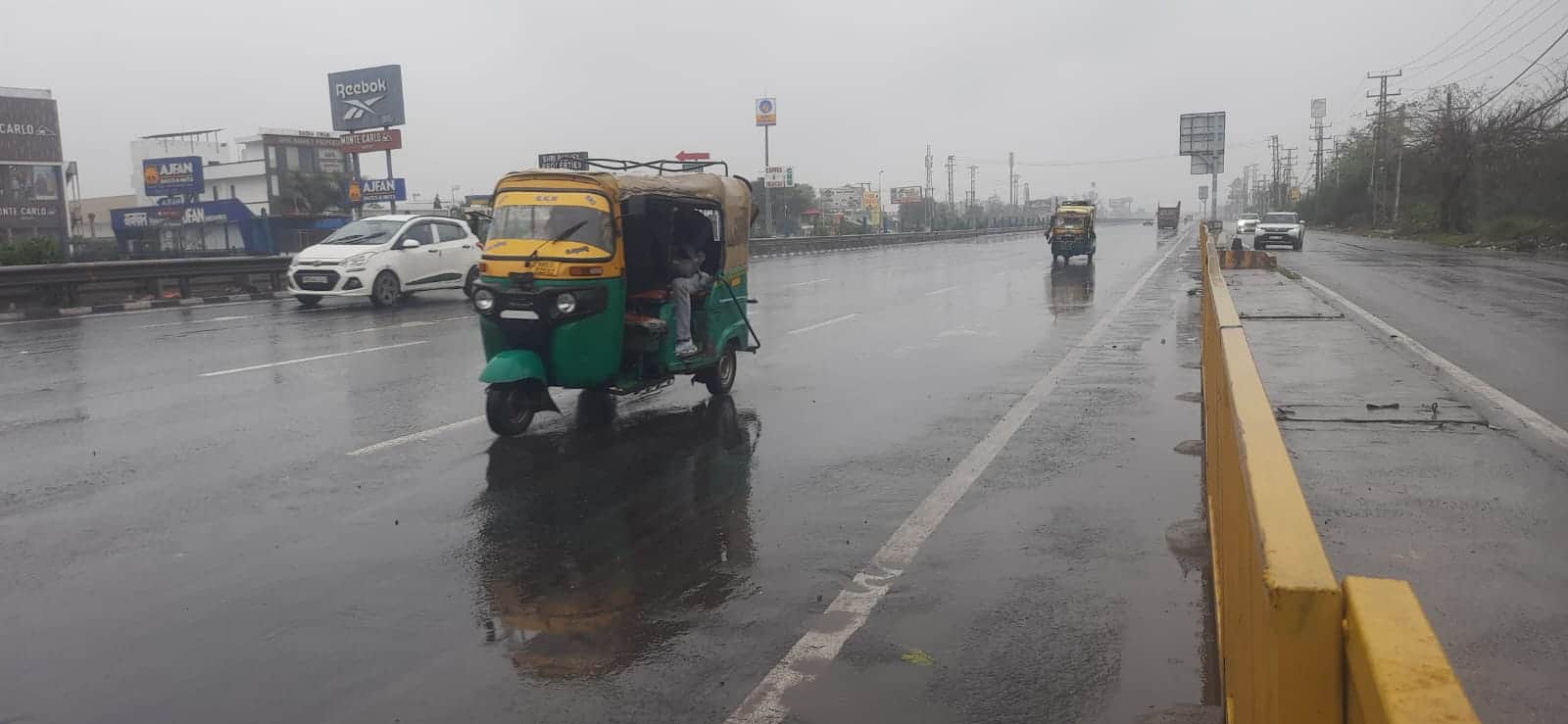 बारिश के दौरान जीटी रोड से गुजरते वाहन। संवाद