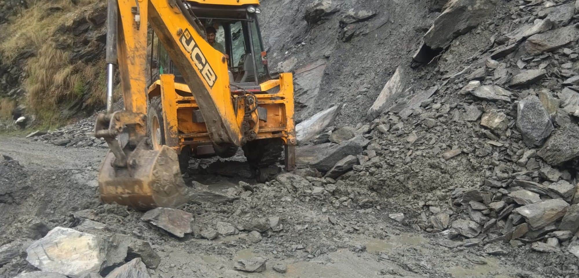 चंबा में बारिश के बाद लोथल घार के पास एनएच को बहाल करने में जुटी  जेसीबी मशीन।संवाद