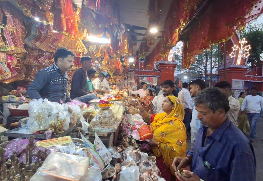 फोटो02 चामुंडा मंदिर पर प्रसार व पूजा की सामग्री का सामान खरीदते भक्त।संवाद