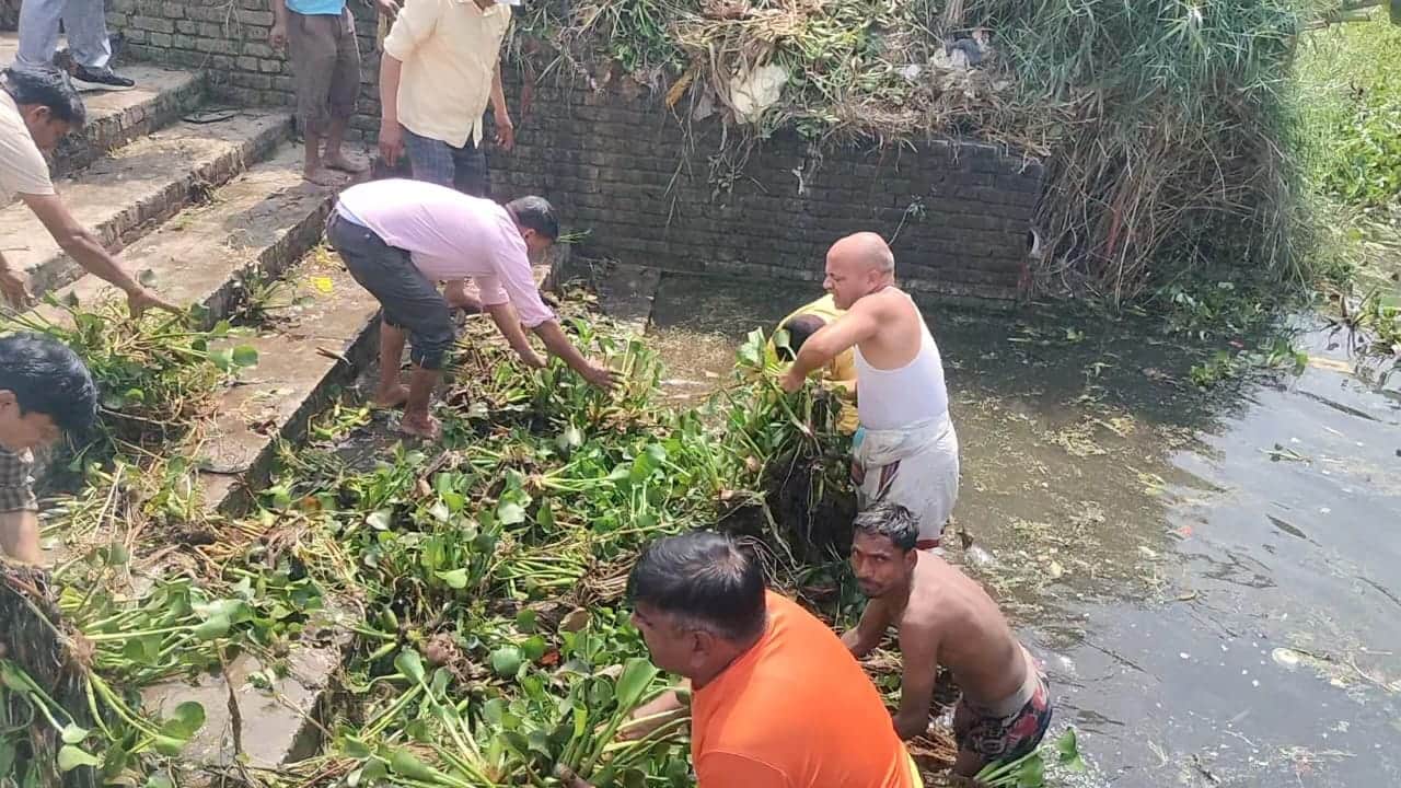 झुंगीनाथ मंदिर के पास मनोरमा नदी की सफाई करते लोग। संवाद