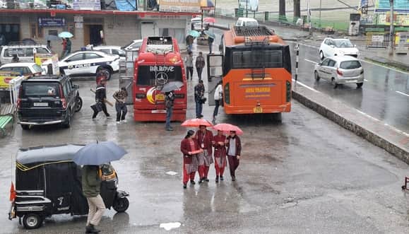 कुल्लू में लगातार हो रही बारिश के बीच परीक्षा देकर लौटती छात्राएं।-संवाद