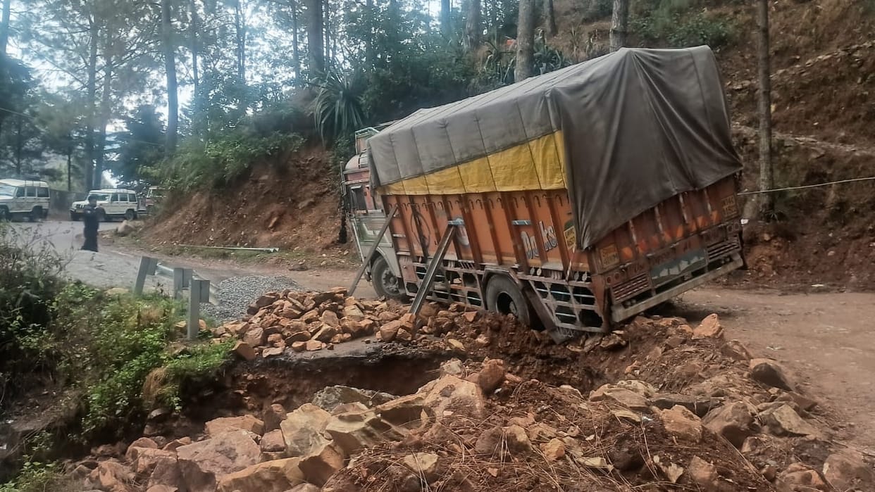 The truck's wheel got stuck in the mud, blocking the road.