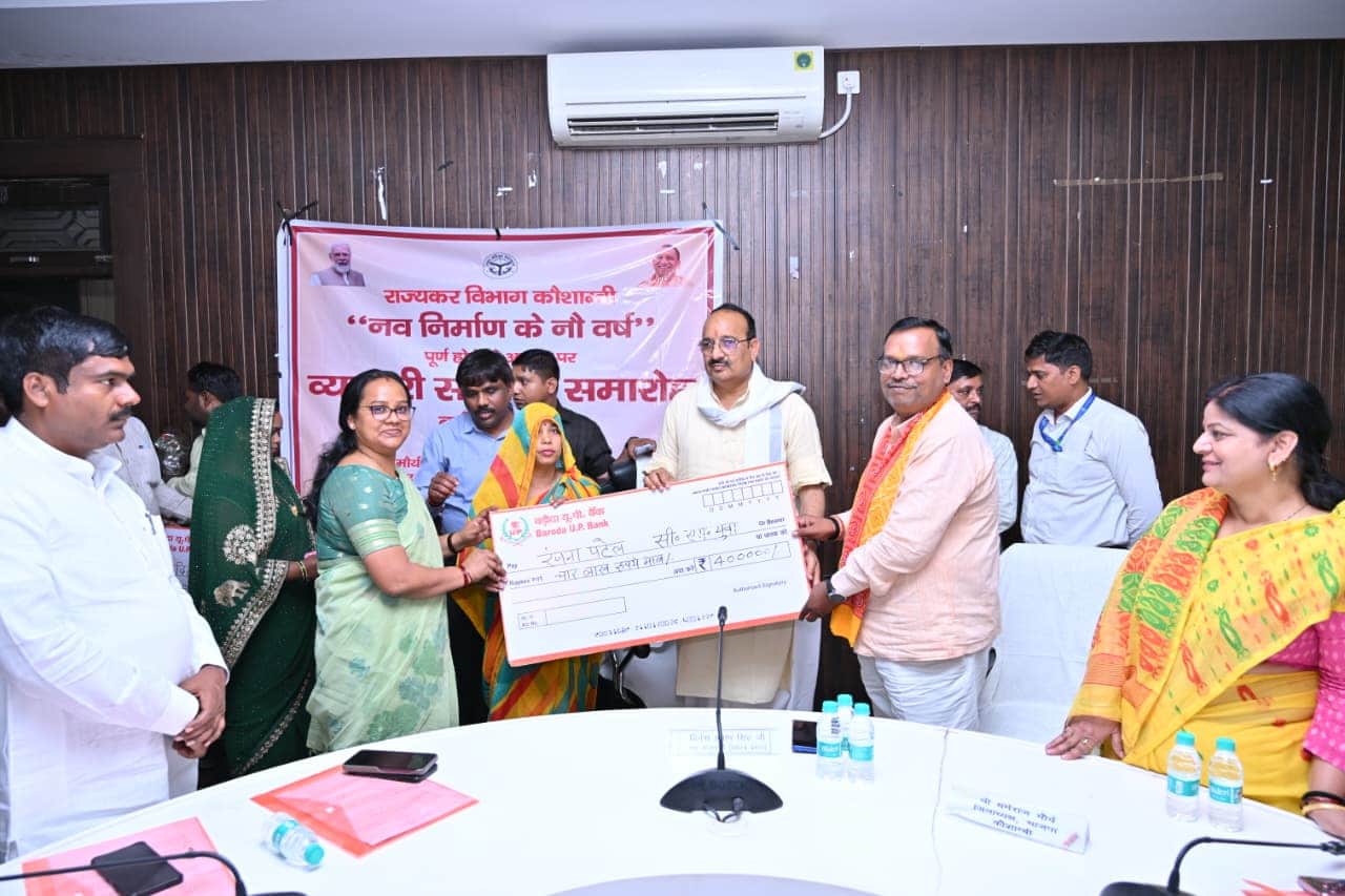 लाभार्थी महिला को डमी चेक देते प्रभारी मंत्री व अन्य पार्टी के नेता। स्रोत: प्रशासन