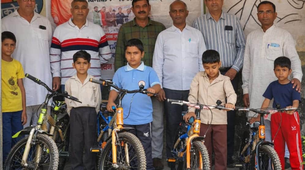 मेधावी बच्चों को साइकिल देकर सम्मानित करते संस्था के सदस्य। स्रोत : स्कूल