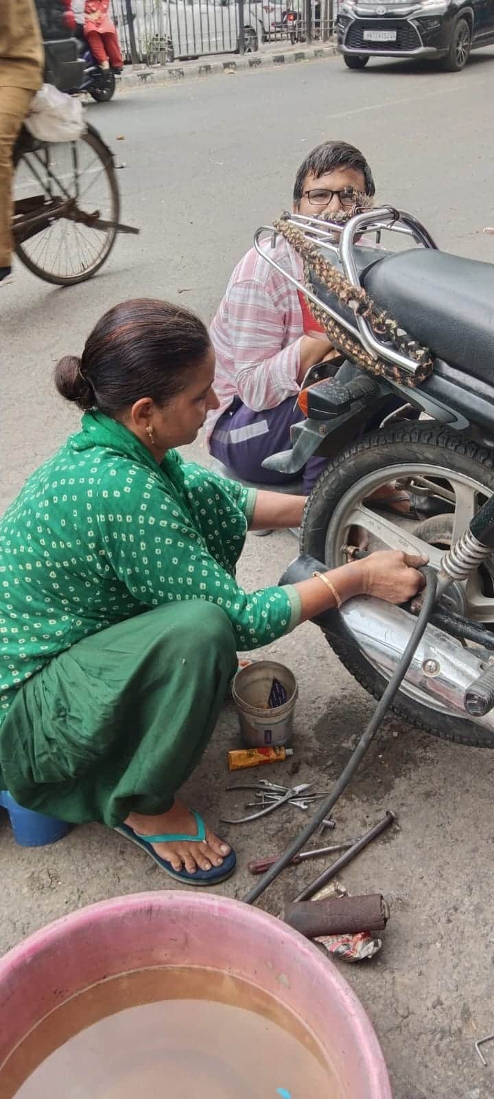 रोहतक में डी पार्क के पास दुकान पर पंक्चर लगातीं मुकेश देवी।