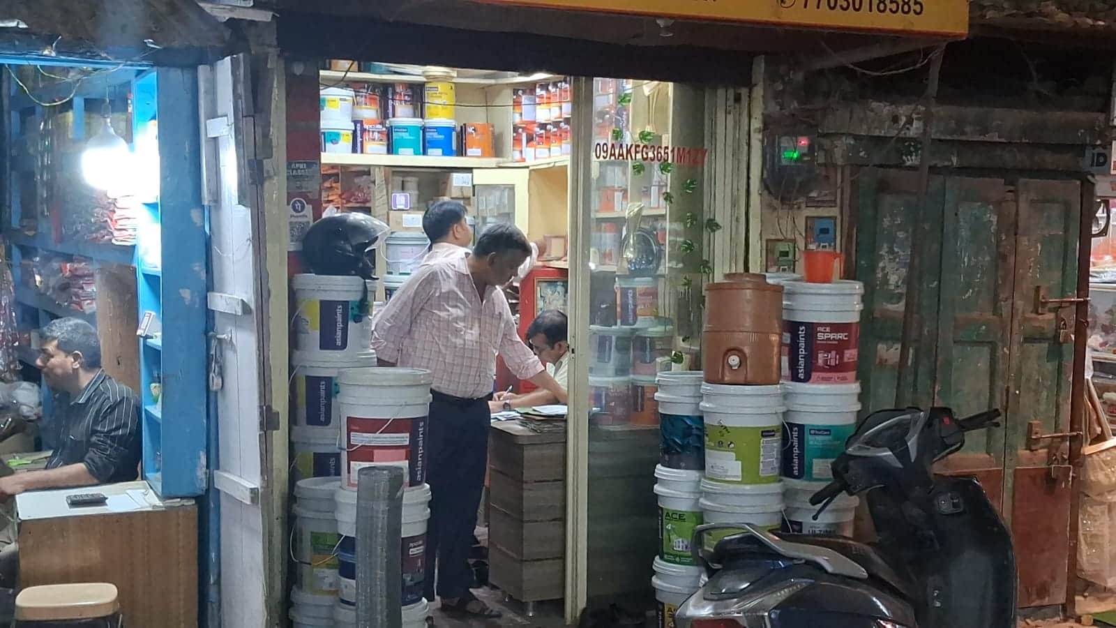 बिहारी जी मंदिर के पास स्थित पेंट की दुकान पर अभिलेख की जांच करता जीएसटी टीम का अधिकारी।