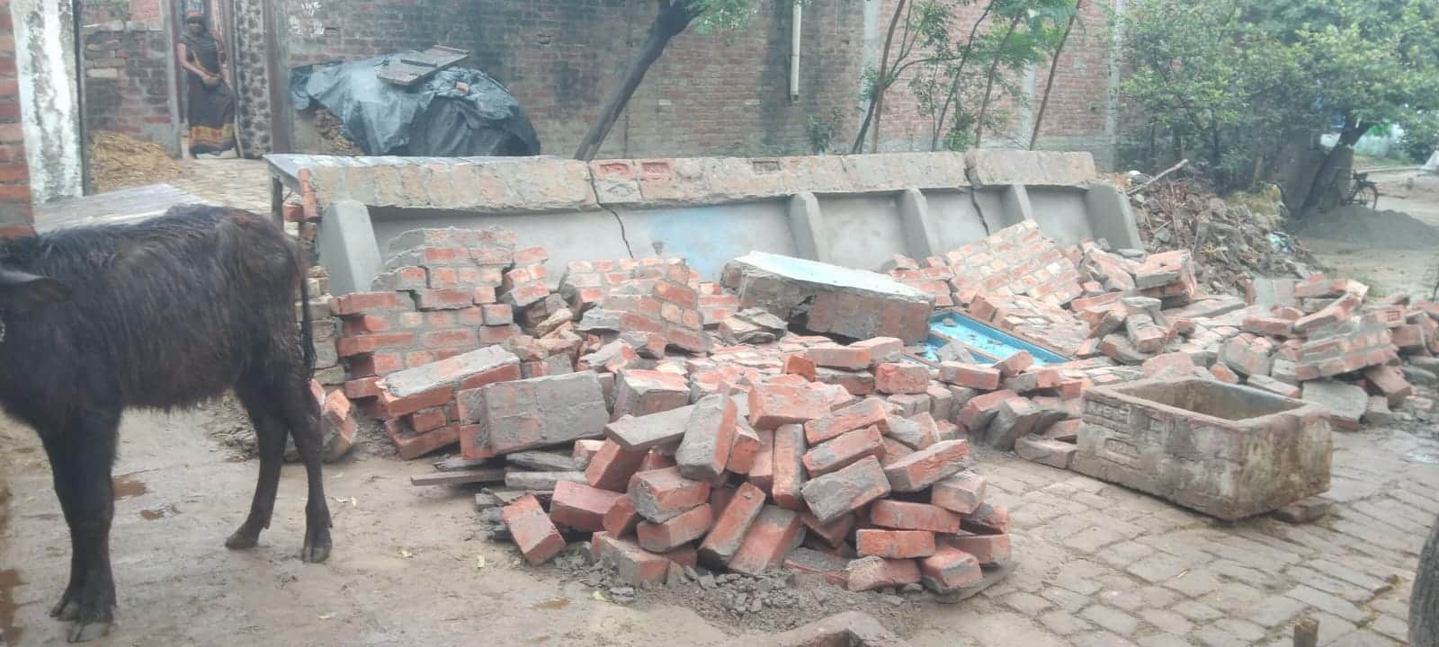 बारिश के बीच गिरी दीवार।