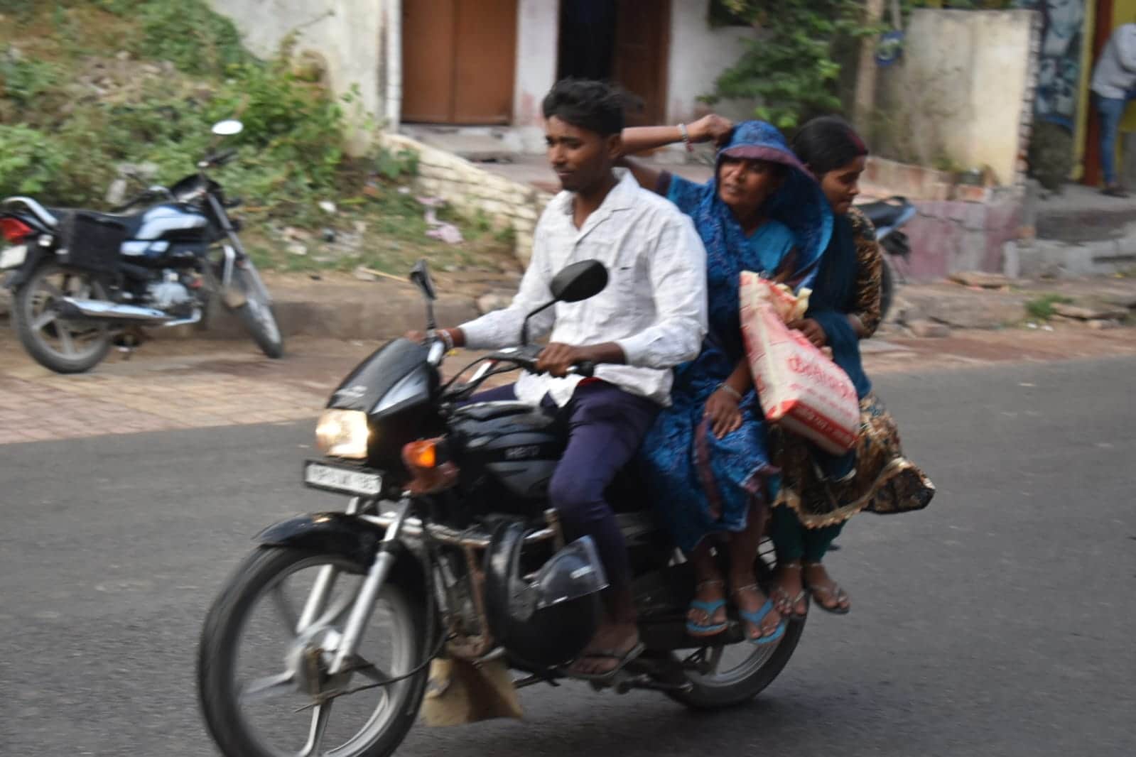 बूंदाबादी के बीच शहर के लंका से होकर गुजरते लोग। संवाद