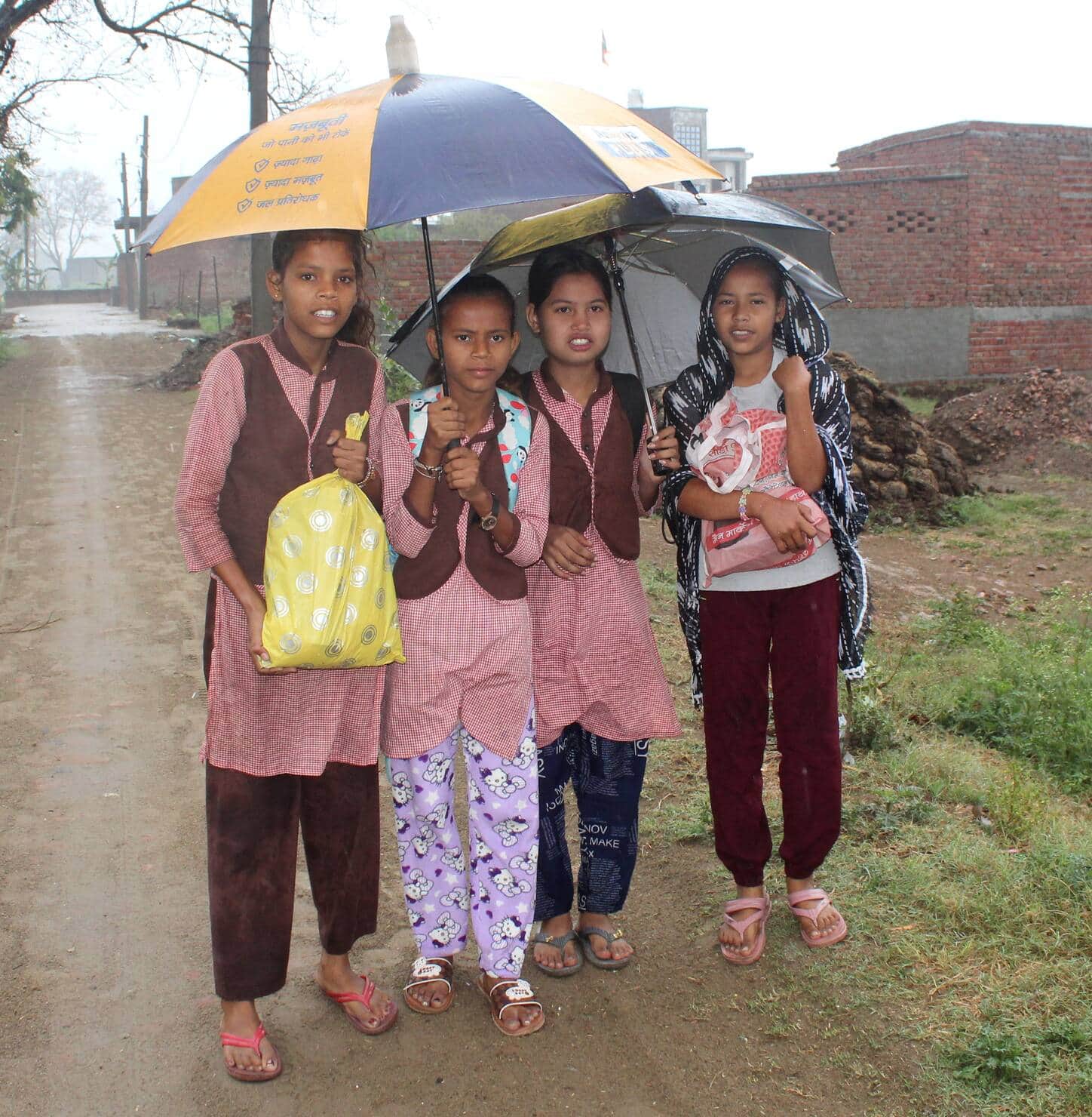 छाता लगाकर स्कूल में परीक्षा देने जातीं छात्राएं। संवाद