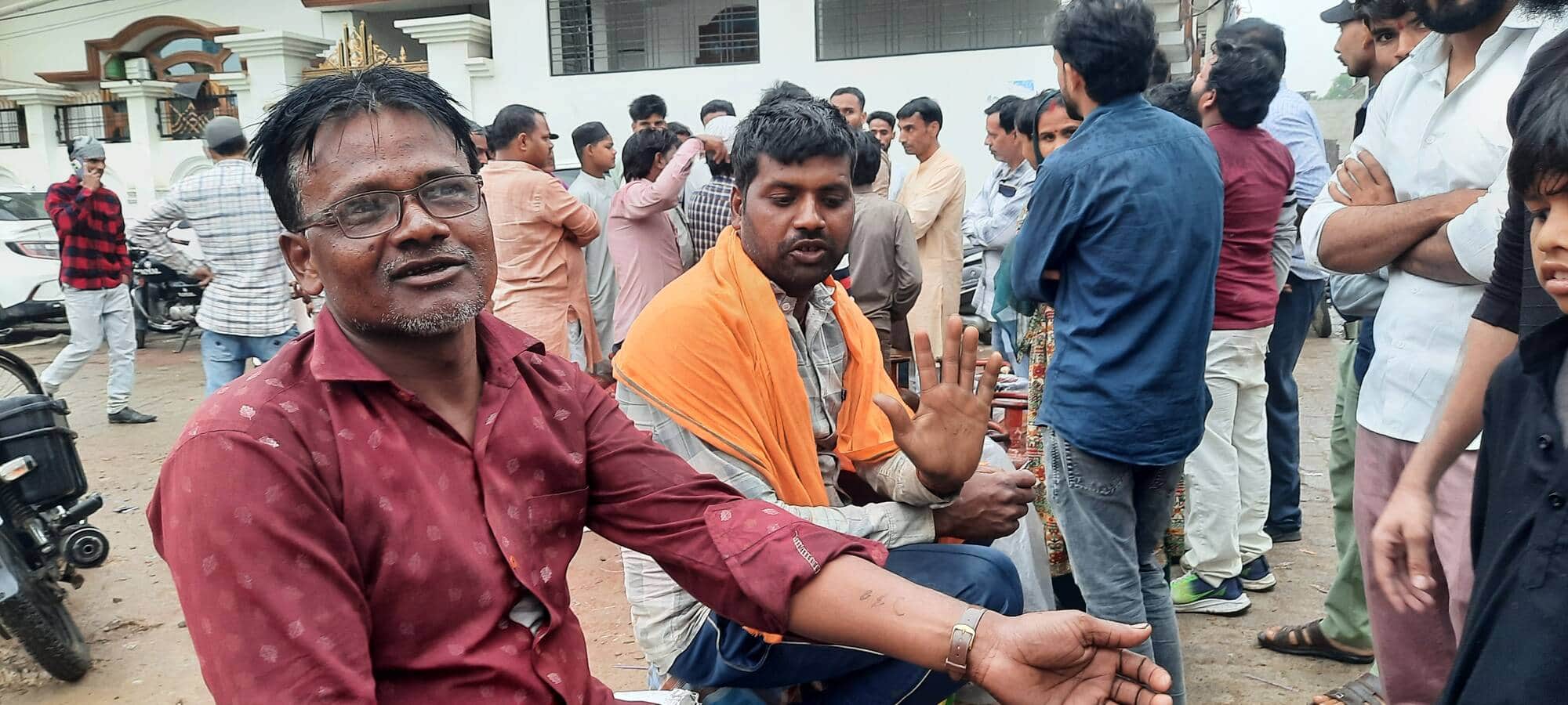 हाथ पर लिखा नंबर दिखाता युवक।