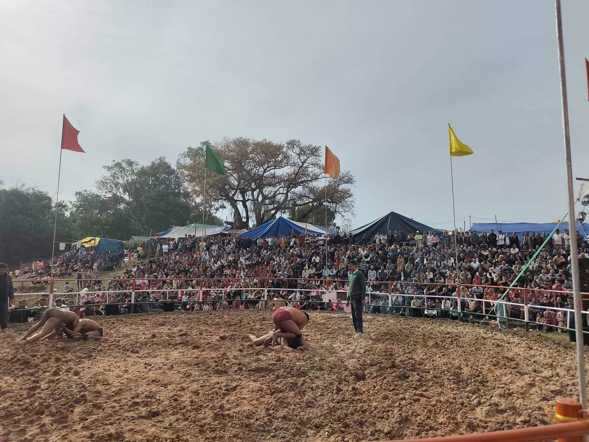 परौर छिंज मेले में कुश्ती के दौरान जोर आजमाइश करते पहलवान और आनंद लेते दर्शक। -संवाद
