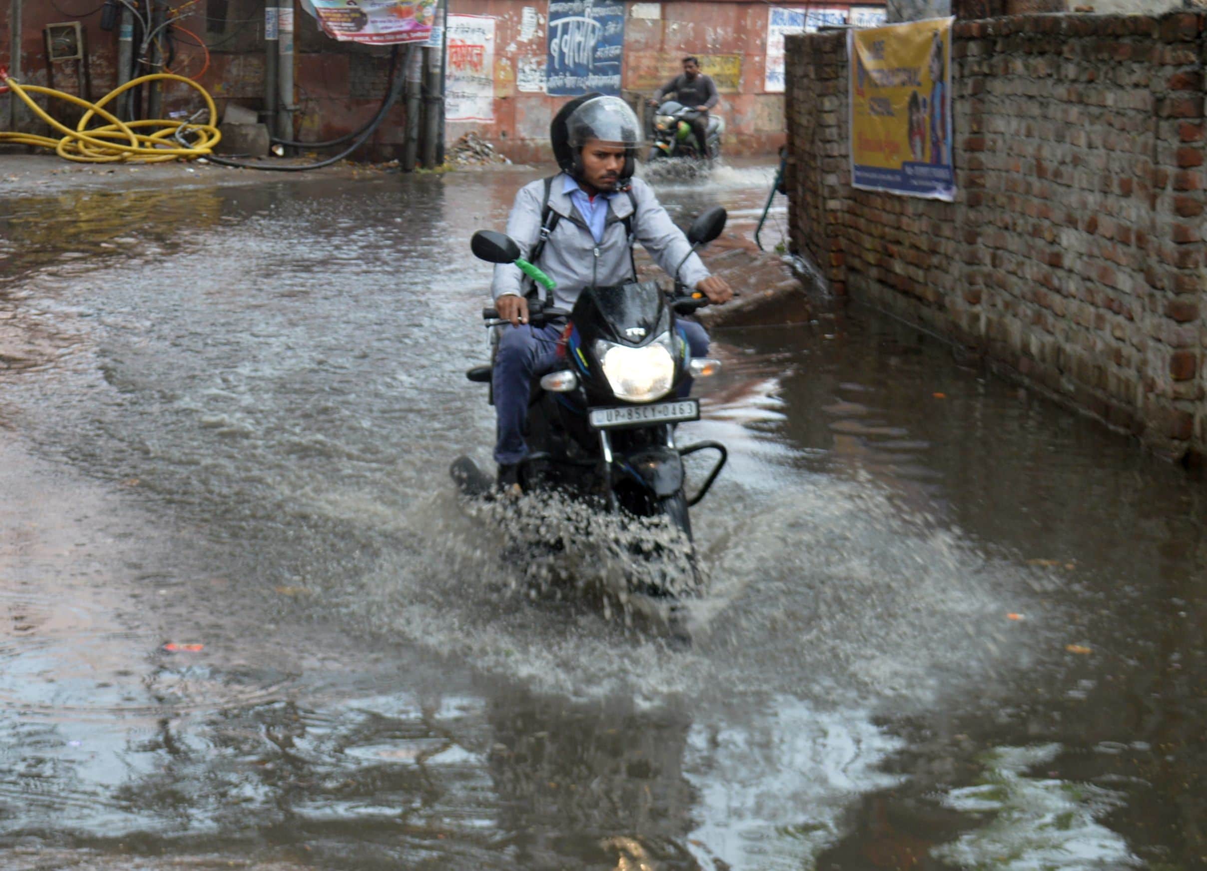 सौंख रोड पर जलभराव में होकर निकलता बाइक सवार। 