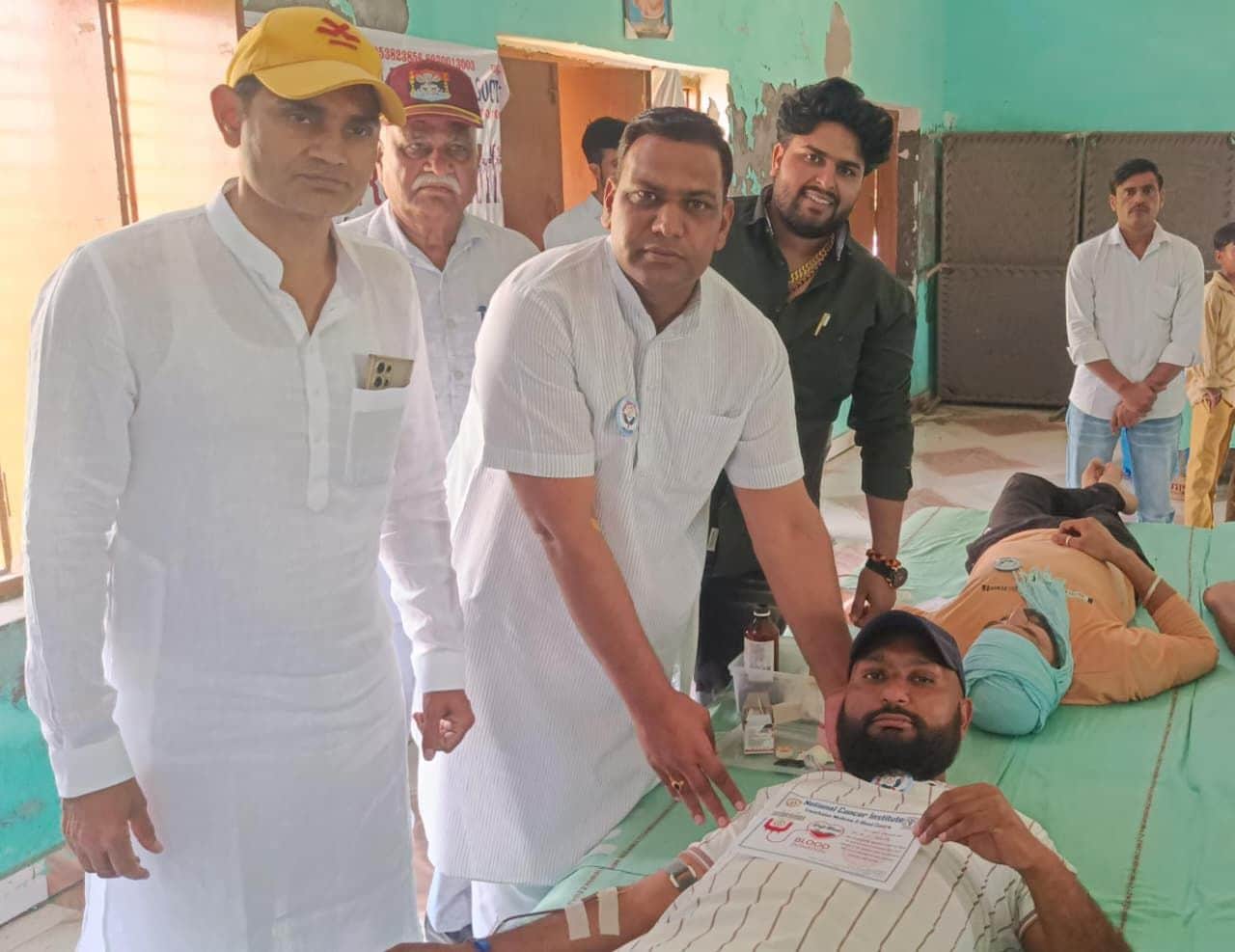 22जेएनडी25: रक्तदाताओं को बैज लगाते हुए मुख्यातिथि। स्रोत ग्रामीण