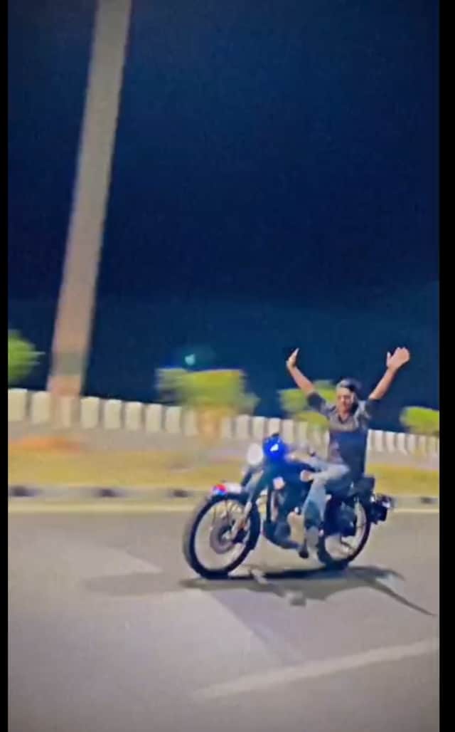 बाइक पर स्टंट करता युवक फोटो वीडियो