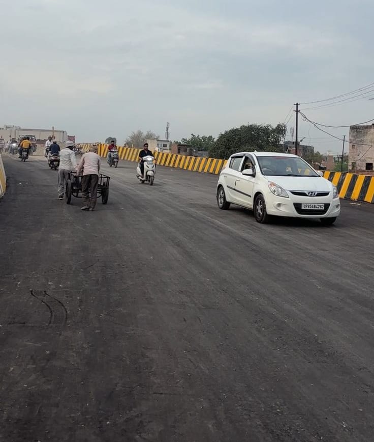 The new bridge over the Dhamola River has been commissioned, with vehicles speeding along.