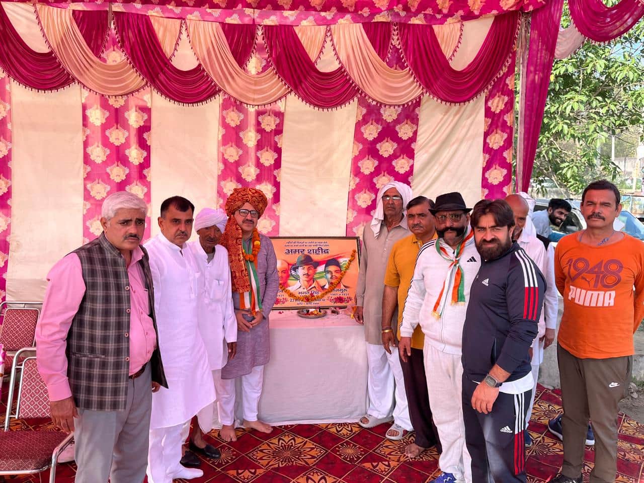 फोटो :: सोनीपत के गांव नाहरी में शहीदी दिवस पर आयोजित कार्यक्रम में शहीदों के चित्र पर पुष्पांज