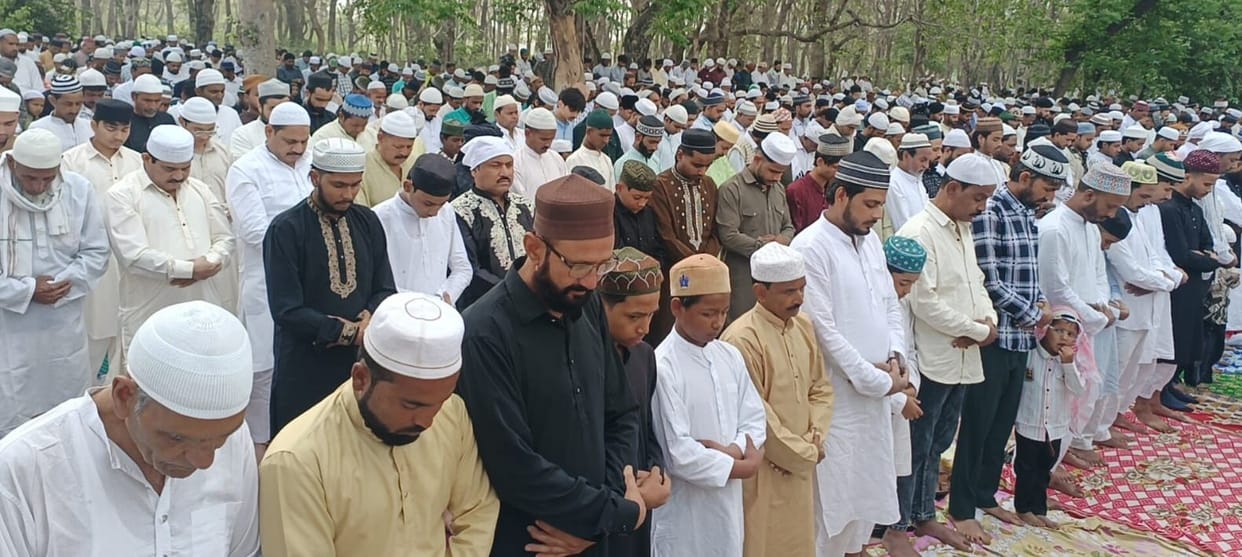 Heads bowed in prostration, hands raised in prayer for peace.