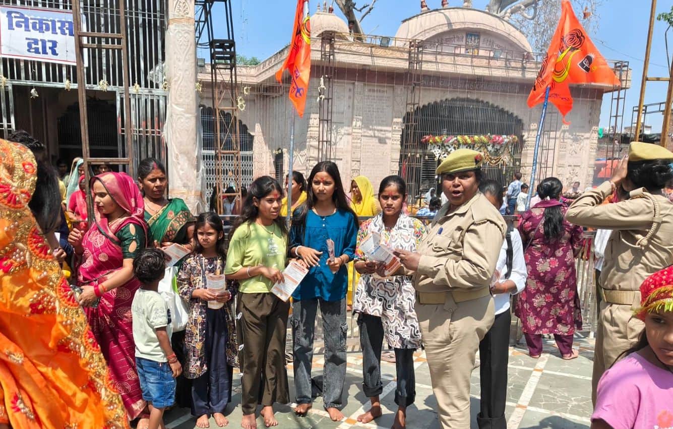 फोटो29कासगंज के चामुंडा माता मंदिर पर बालिकाओं को सुरक्षा संबंधी जानकारी देतीं पुलिस कर्मी।