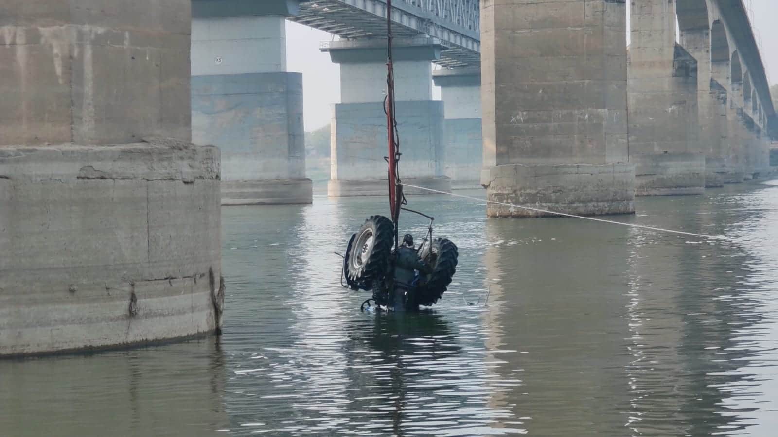 गंगा से निकाला जा रहा ट्रैक्टर। संवाद