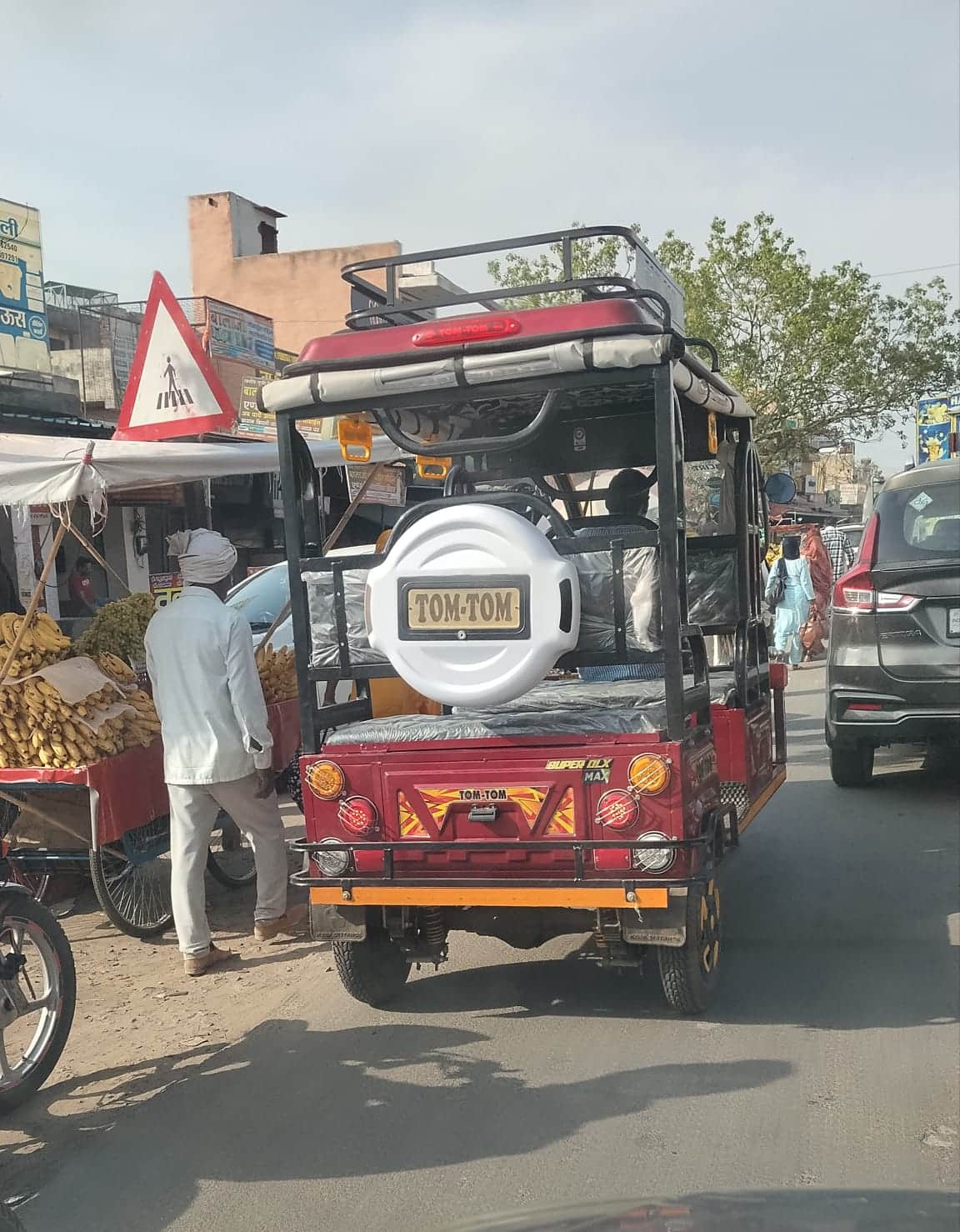 सड़क पर खड़ा अधिक चौड़ाई क्षमता वाला ई-रिक्शा। संवाद