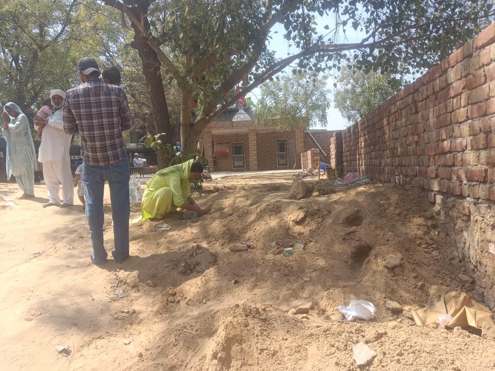 शहर में मावड़ी माता के मंदिर में मिट्टी निकालते हुए श्रद्धालु। संवाद