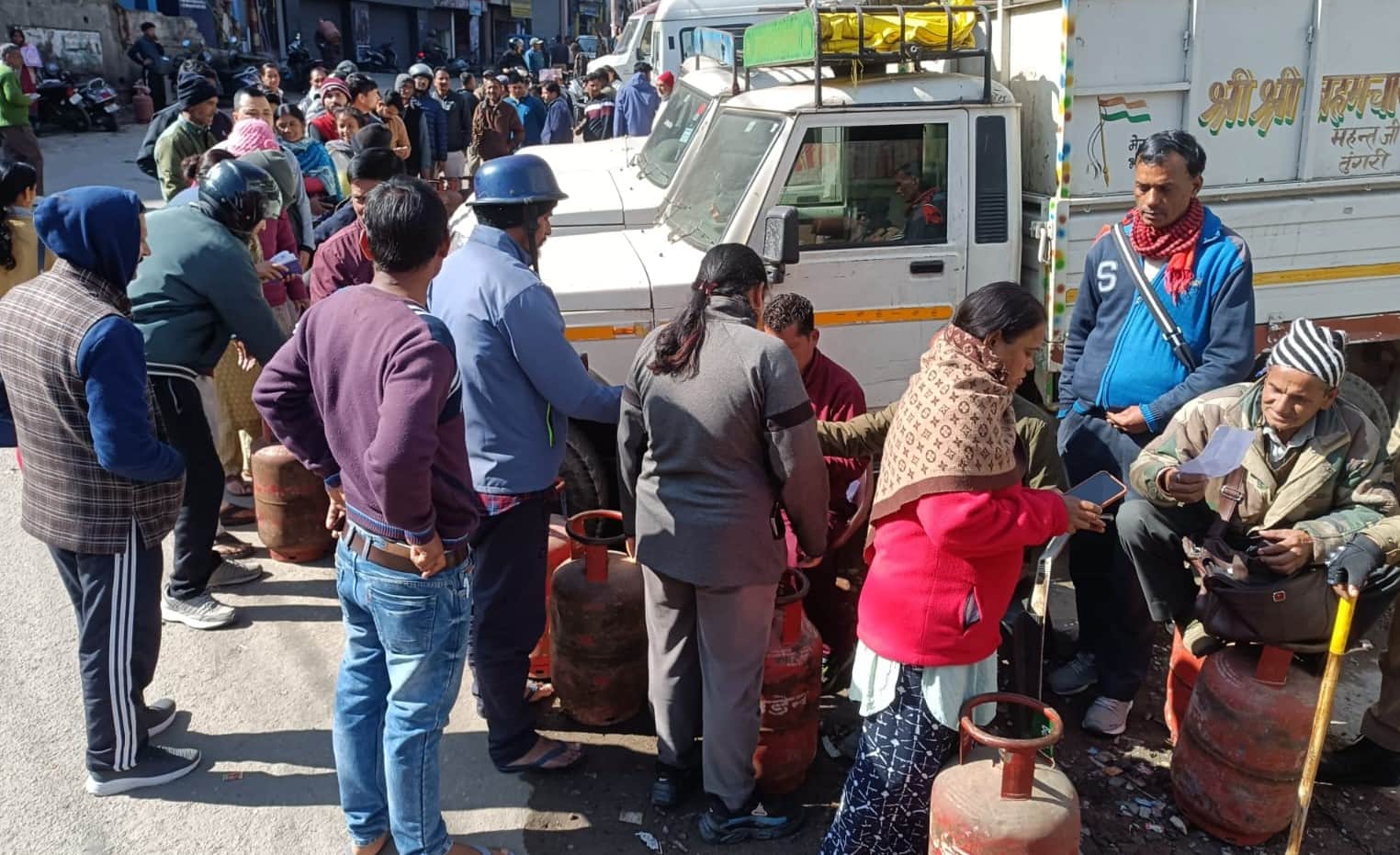  शिखर तिराहे पर पार्किंग के पास गैस सिलिंडर बांटते निगम कर्मचारी। संवाद