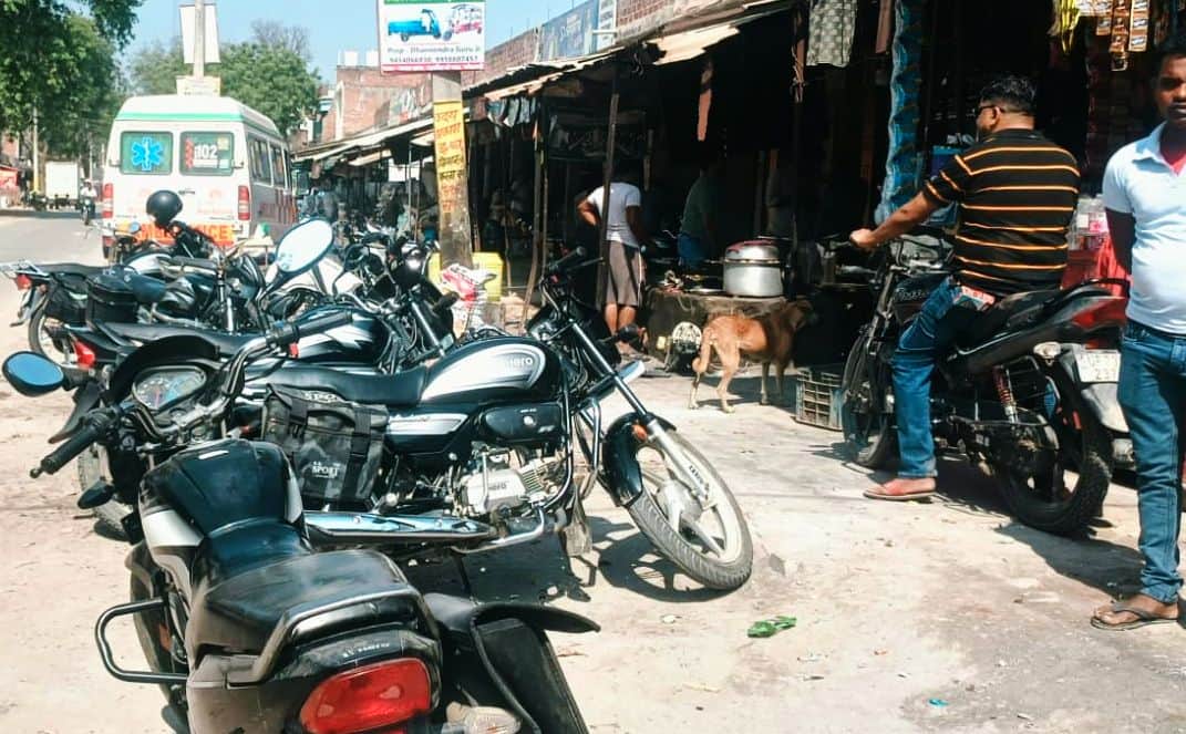 चरवा कस्बे में सड़क की पटरी पर खड़ी बाइकें।  संवाद